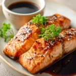 Close-up of air fryer salmon with soy sauce glaze on a white plate
