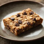 When Afternoon Cravings Hit: Chocolate Chip Oatmeal Cookie Bar to the Rescue 3 Close-up of chocolate chip oatmeal cookie bars with visible chocolate chips and a golden-brown texture.