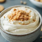 A Sweet Sugar Cookie Dip to Satisfy Midday Cravings 3 Close-up of sugar cookie dip with sprinkles in a white bowl on a clean background.