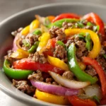 Close-up of sizzling ground beef fajitas with colorful peppers and onions