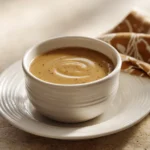 Close-up of chicken in creamy sauce with herbs, perfect for low calorie chicken gravy.