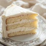 Close-up of vanilla cake with cream cheese frosting on a minimal background