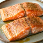 Close-up of air fryer salmon with a drizzle of olive oil on a clean plate