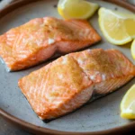 Close-up of baked salmon in an air fryer with a clean background