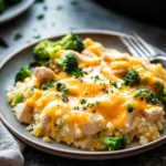 Cheesy chicken broccoli rice casserole with melted cheese and broccoli florets