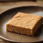 Close-up of gluten free peanut butter cookie bar with a golden crust and visible texture