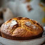 Close-up of pumpkin bread in a dutch oven with a golden crust.