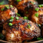 Close-up of skillet jerk chicken with vibrant spices and herbs in a cast iron skillet.