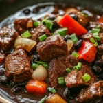 Close-up of slow cooker beef in black bean sauce with vibrant colors and textures