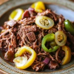Close-up of slow cooker Melissa Jo Italian beef with bright lighting and minimal background.